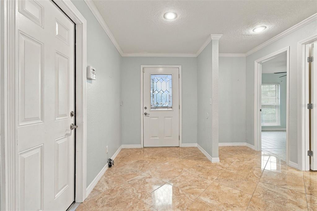 The foyer is spacious for entry furniture. The wall keeps the front bedroom private from the entry.