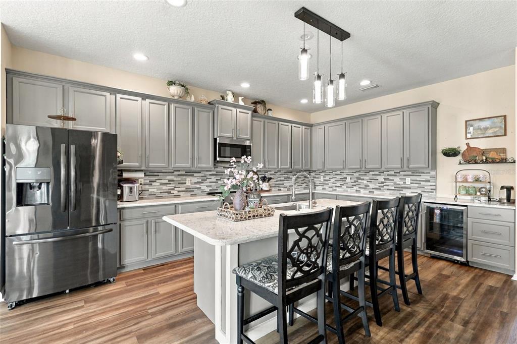 Look at this gorgeous updated kitchen with custom tile backsplash and quartz countertops.