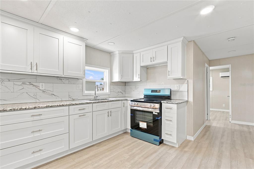 Open floorpan - Kitchen with shaker cabinets and granite counters. All New stainless steel appliances.