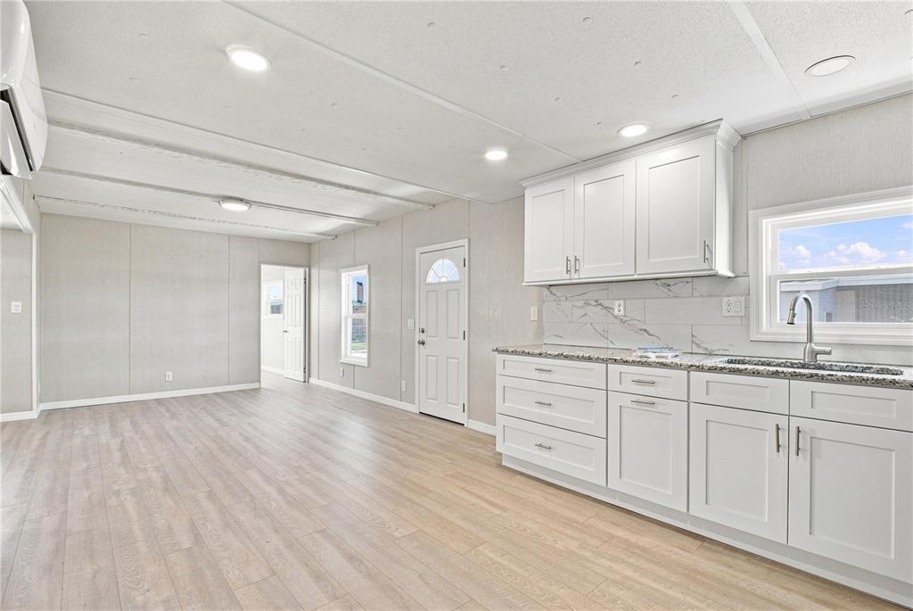 Open floorpan - Kitchen with shaker cabinets and granite counters.