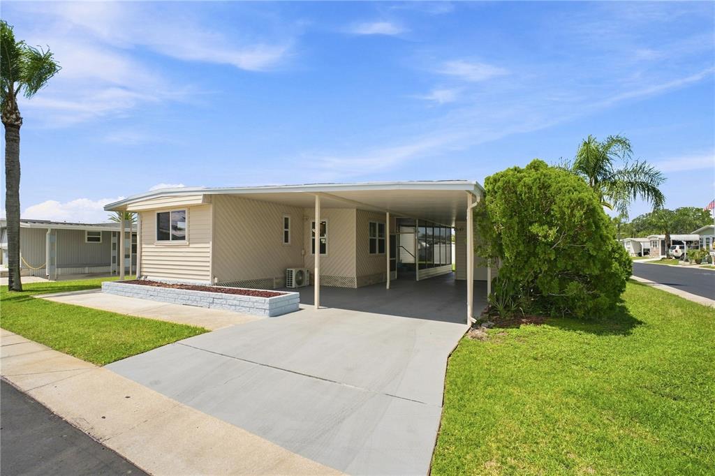 Front of home. Corner lot, end unit. East -Facing. Carport and golf cart parking with Florida room.