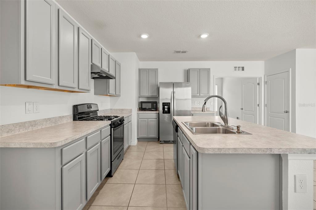 Spacious kitchen featuring stainless steel appliances, generous cabinetry, and ample counter space.