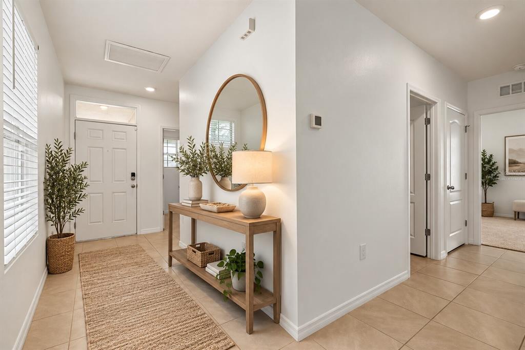 Virtually staged bright, welcoming entryway with neutral finishes and an open, airy feel.
