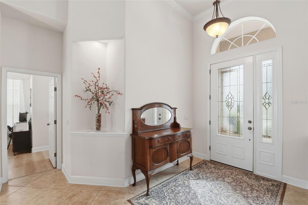 Foyer – Welcoming entry with a decorative glass front door, matching sidelight, arched transom window, and high ceilings for a bright, open first impression.
