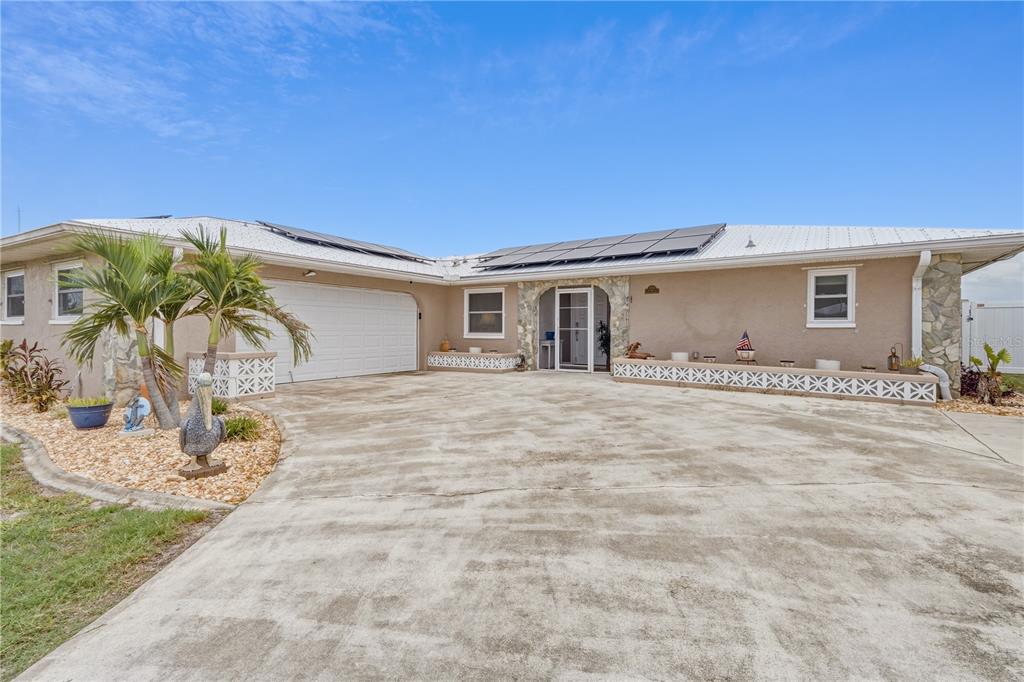 Welcoming Front Exterior with Metal Roof and Paver Driveway