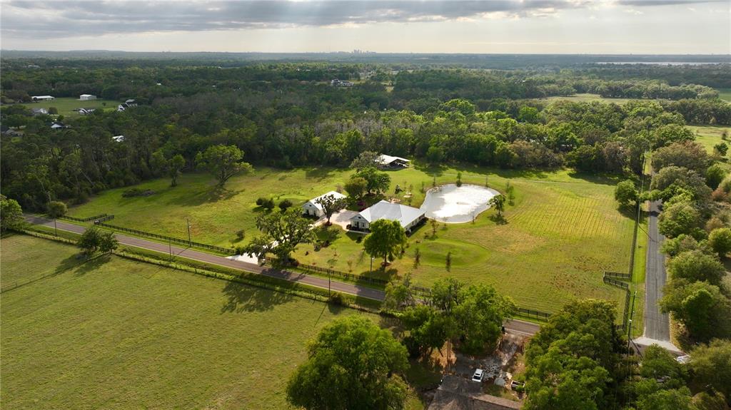 Fenced estate features the main house, a guest cottage, a pond, a creek and pole barn