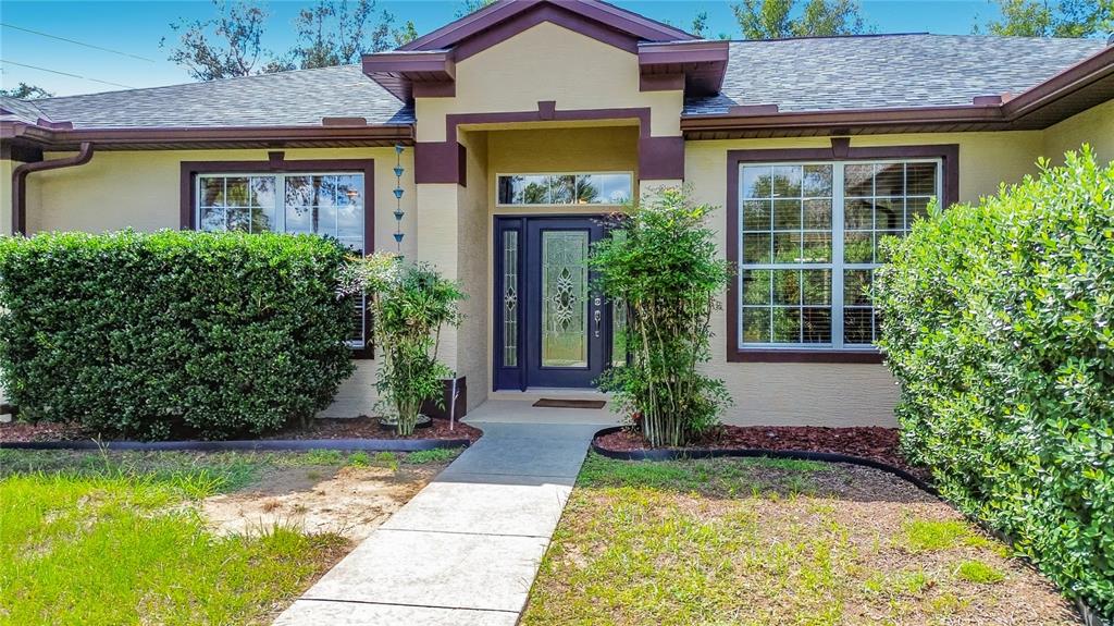 Covered front entry framed by landscaped hedges