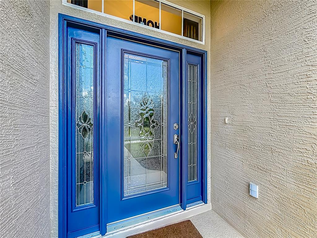 Striking blue double front doors with decorative glass