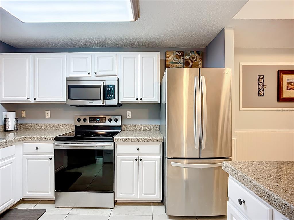 Kitchen has views to living room, dining room, and screened lanai overlooking greenspaces offering privacy.