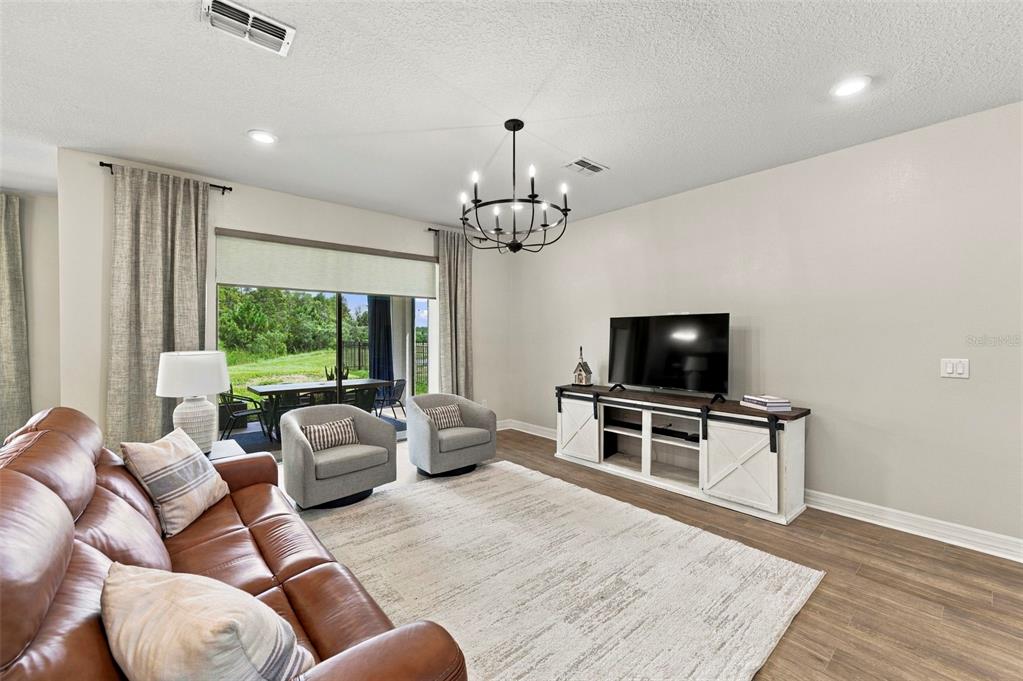 Living room opens to the screened lanai and view of the pond and conservation area