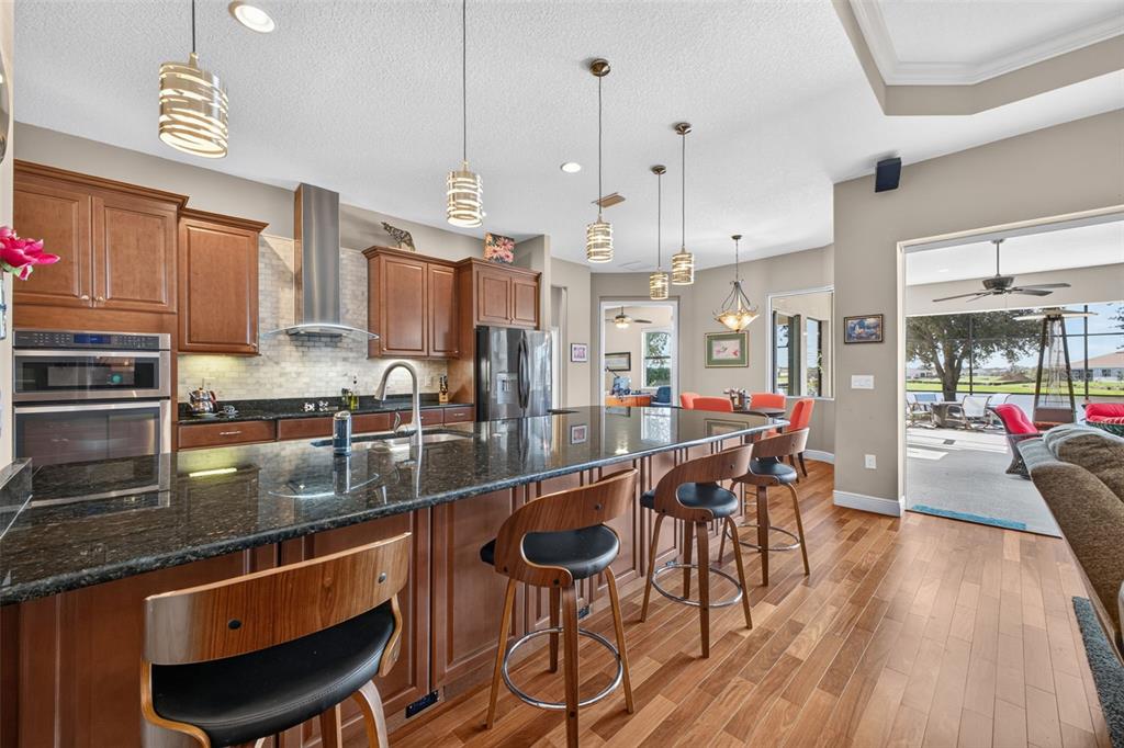 Durable granite countertops and rich wooden cabinetry elevate the kitchen, while a generous peninsula offers both extra storage and a welcoming spot for casual seating.