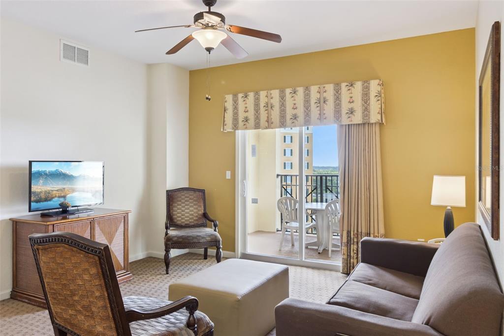 Living Room | Sliding glass doors fill the living area with natural light and provide direct access to the covered balcony.