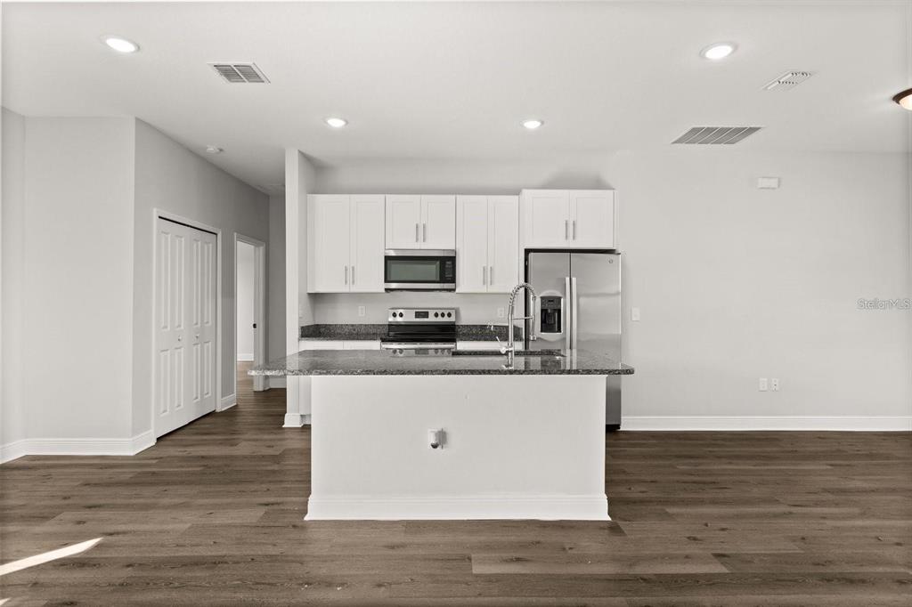 Kitchen comes with stainless steel appliances and an island