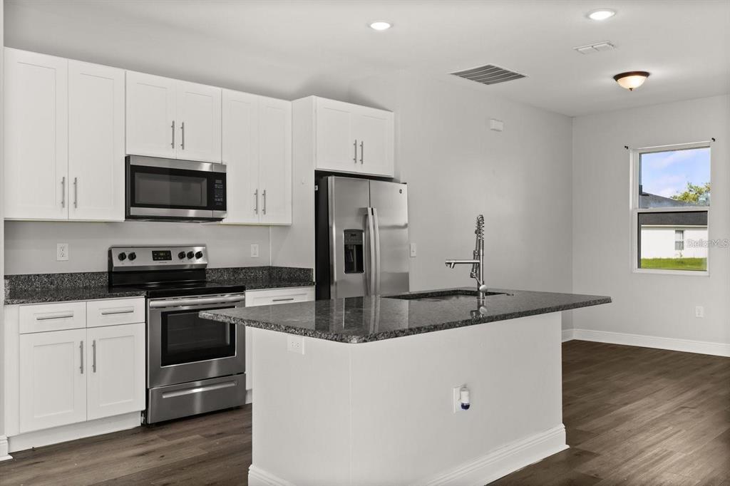 Kitchen comes with stainless steel appliances and an island