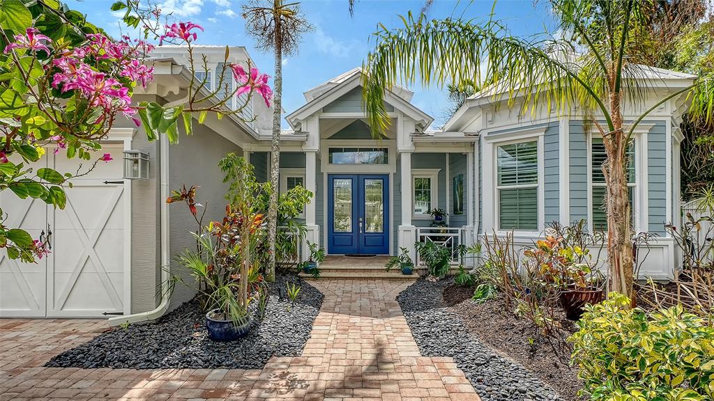 The paver driveway and walkway lead to a welcoming double French door entry