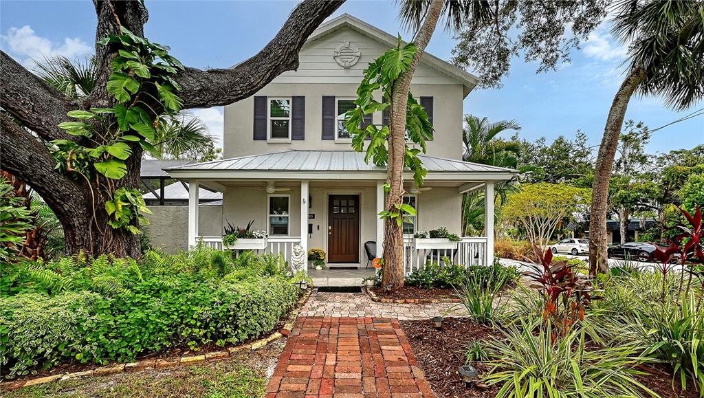 Beautifully landscaped Key West–inspired residence welcomes you with timeless architectural character, mature tropical landscaping, and an impressive oak tree.