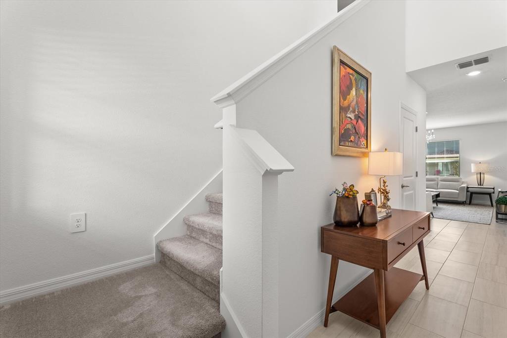 Entryway with carpeted staircase leading to the second floor.