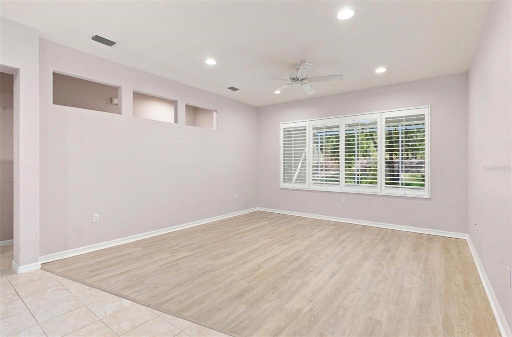 Formal Dining Room features vinyl flooring, Plantation Shutters, and overlooks the Formal Dining Area.