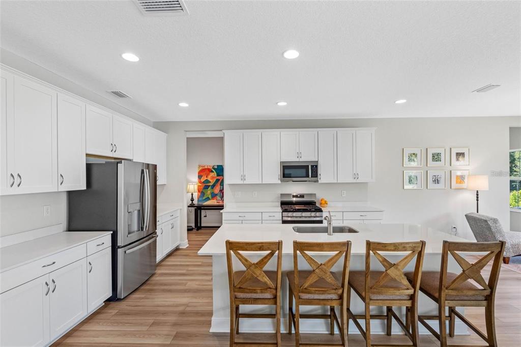 Kitchen with quartz countertops, a seating island, and a gas range