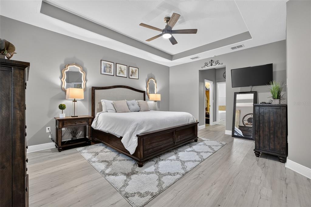 Large primary bedroom suite with tray ceiling and dual walk-in closets.