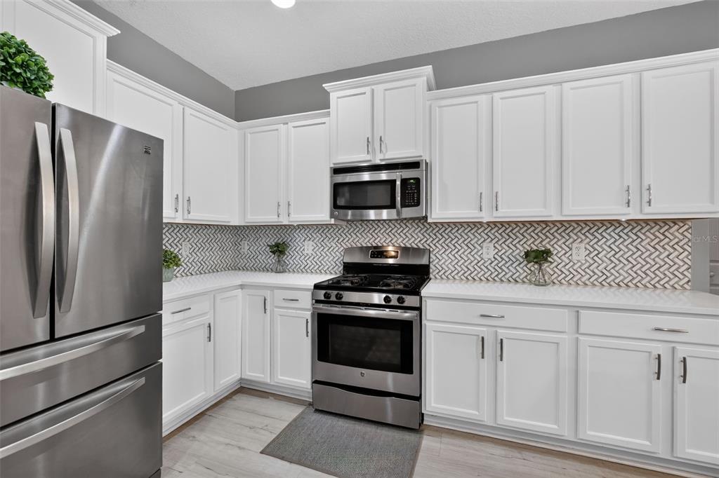Stunning kitchen featuring tons of cabinetry, custom tile backsplash and stainless steel appliances!!