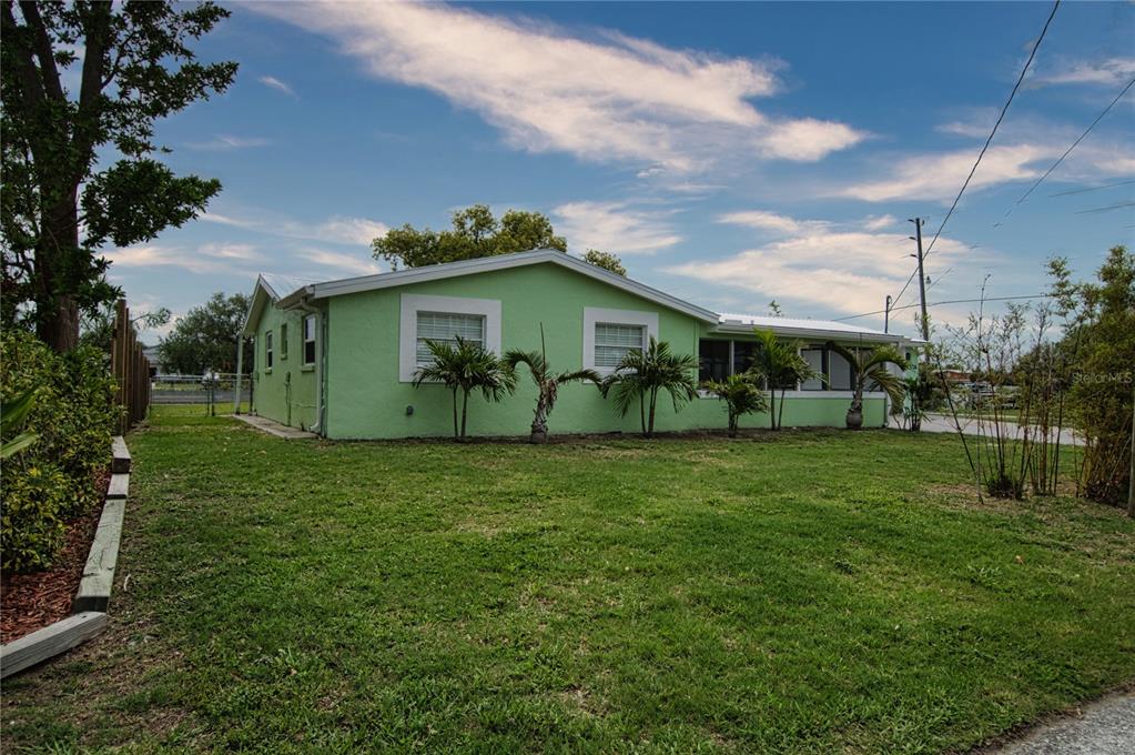 Expansive side yard as well graced by stately palm trees.