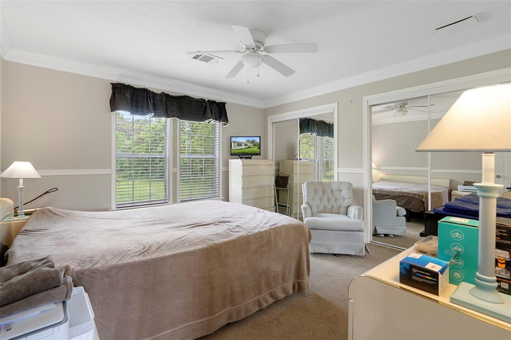 Primary bedroom features generous natural light, ceiling fan and two walk-in closets for substantial storage.