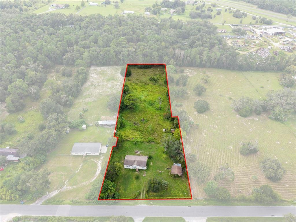 Aerial view highlights the 2.5-acre property, road frontage and the home's position on the fully fenced AG-zoned acreage.
