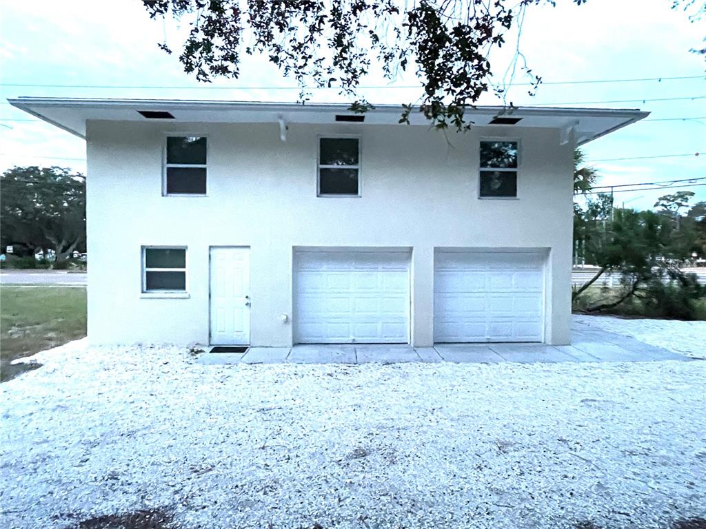 South side of the house. Pedestrian door on left is access to the 3rd bedroom/guest suite/home office w/full bath.