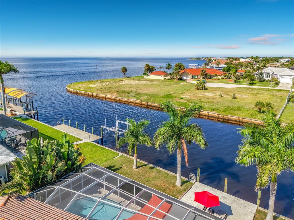Aerial Waterfront View – Elevated aerial view highlighting the property's canal-front location and proximity to expansive open water.