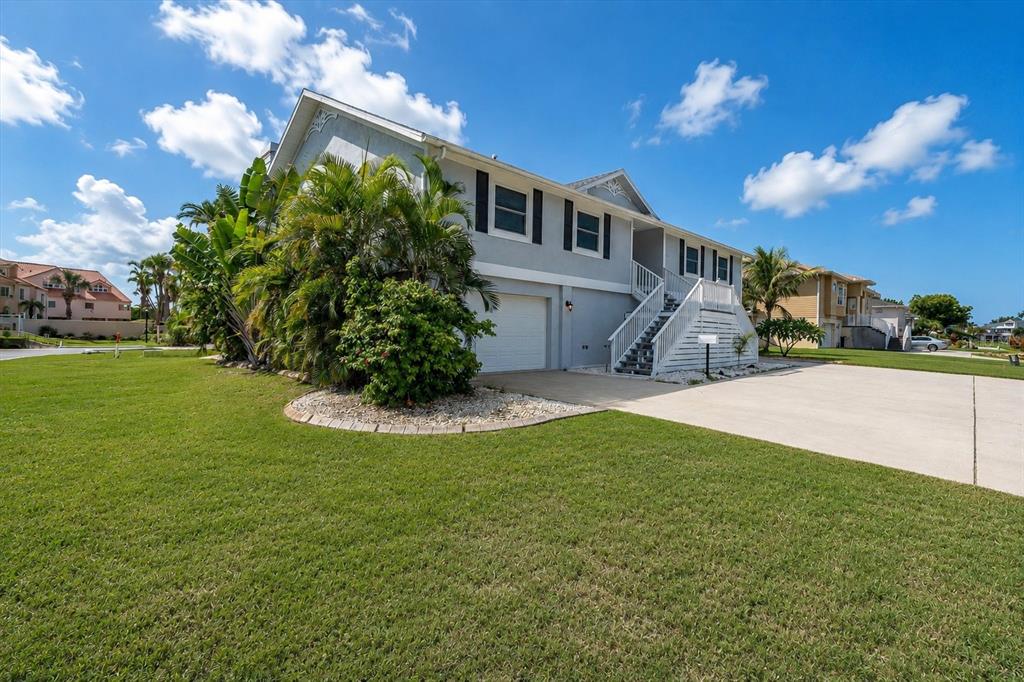 Expansive corner property beautifully framed by lush, mature tropical trees and landscaping.