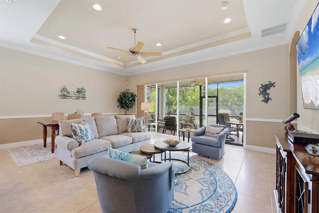 Great Room with great view, custom details like wainscoting, tray ceiling and crown molding in warm neutral monochromatic color palette.