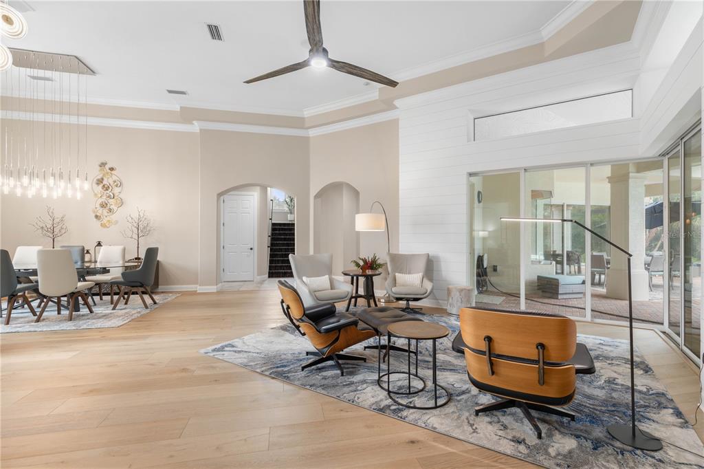 Soaring ceilings and warm wood flooring set an elegant tone, while expansive sliders erase the boundary between the great room and lanai for effortless indoor-outdoor living.