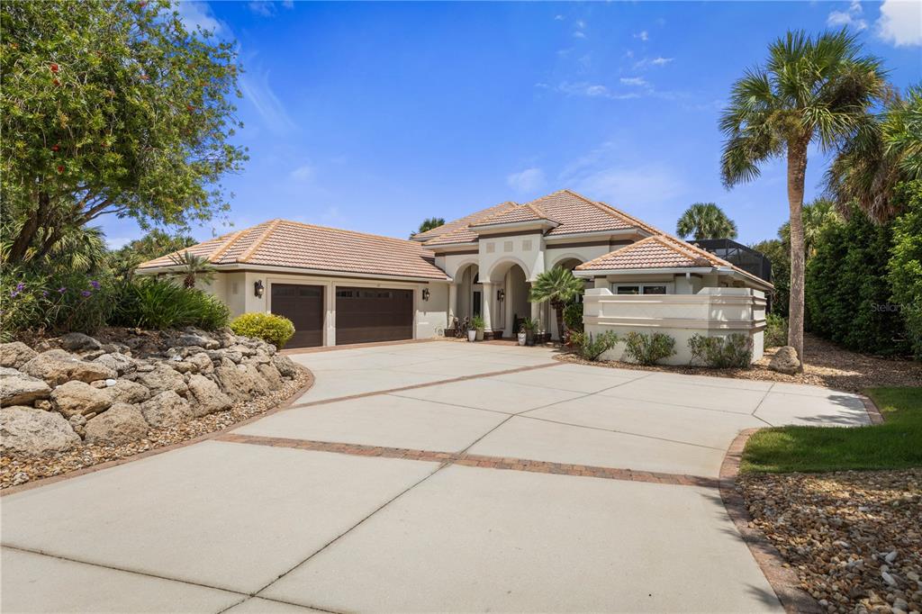 A grand welcome to 113 Island Estates Pkwy, where mature tropical landscaping and timeless architecture set the stage for the waterfront lifestyle waiting beyond the front door.
