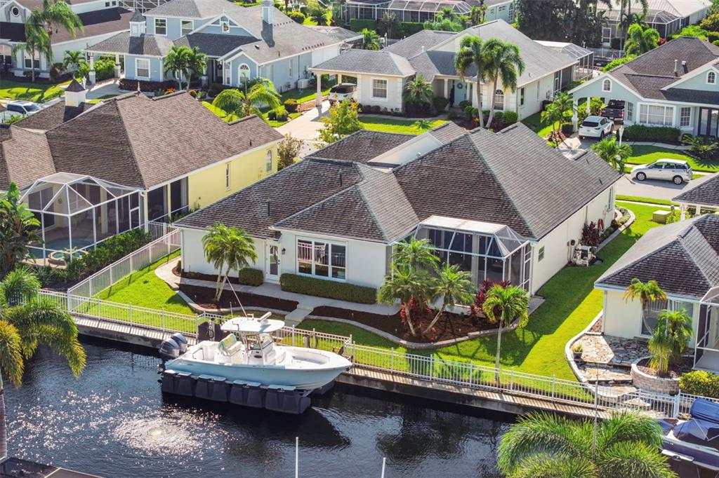 Welcome to 4739 Compass Drive—a beautifully renovated waterfront home with inviting curb appeal and tropical landscaping in The Inlets. An aerial perspective of the home’s freshwater canal setting, with 75 feet of waterfront and boating access through the community canal and lift system.